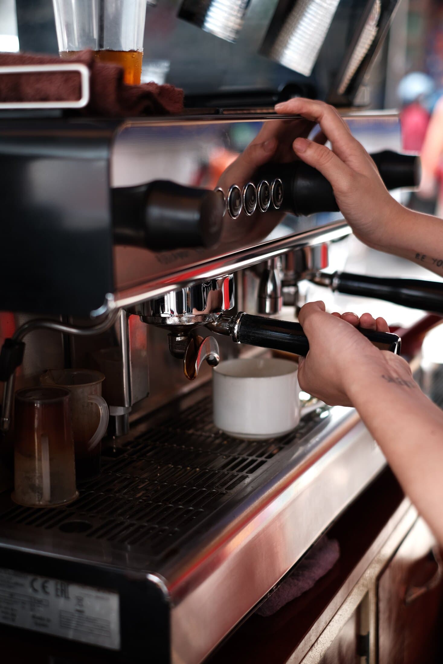 Hands preparing coffee with a professional espresso machine